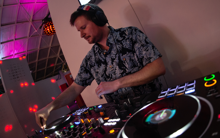 A DJ playing at an evening event