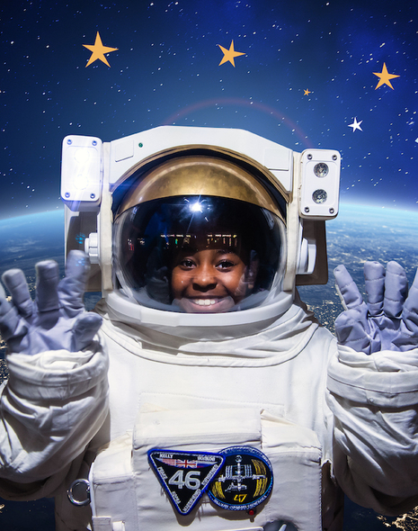 Christmas event promotional image showing a person in an astronaut suit surrounded by floating objects in space.